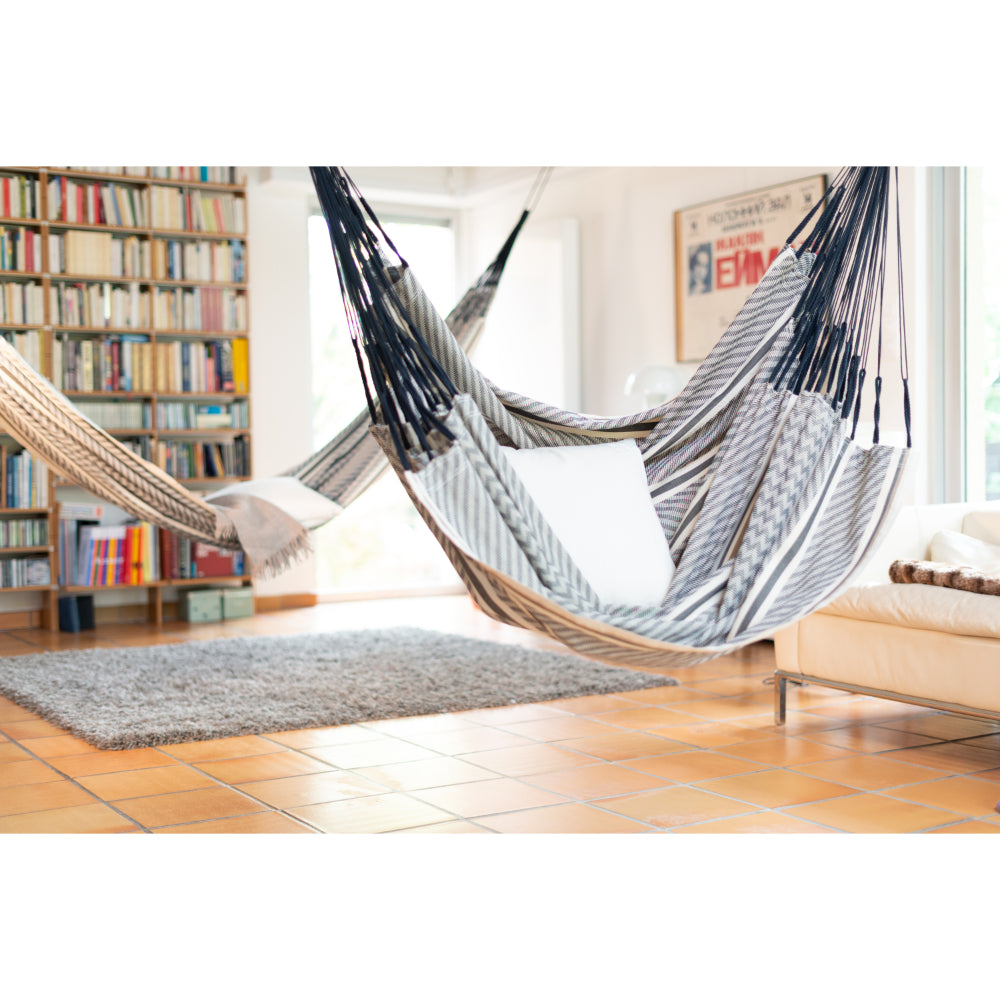Hammock chair hung inside with a pillow sitting in it