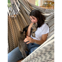 Young girl relaxing in hammock chair with kittens