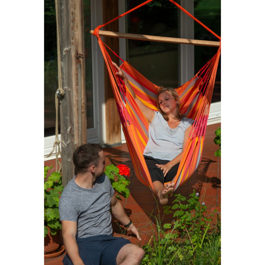Woman lying in hammock chair on porch