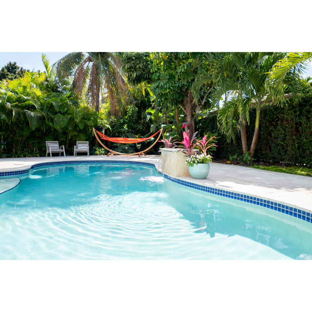 Brightly coloured hammock hanging beside swimming pool