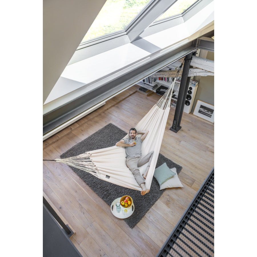 Large white indoor hammock, suspended from steel beams