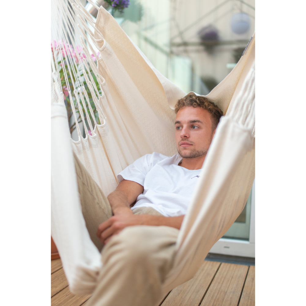 Young man lying back in cotton hammock chair