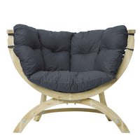 A curved wooden lounge chair with thick, dark gray tufted cushions