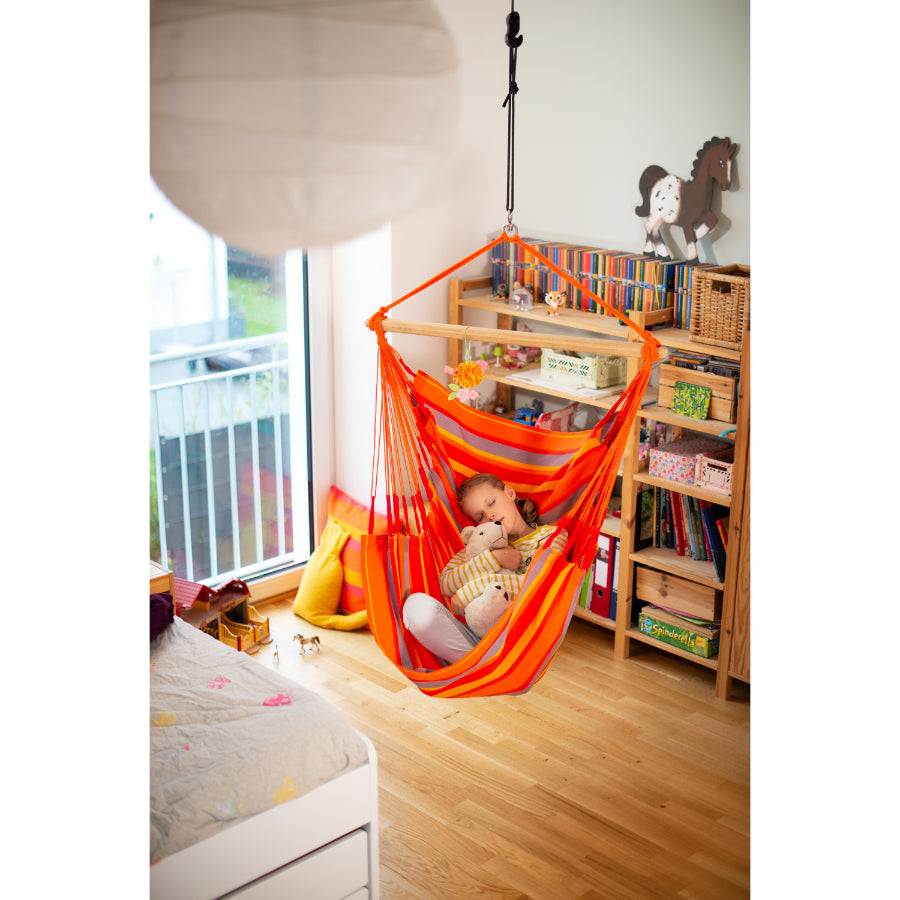 Child napping in hammock swing chair in bedroom