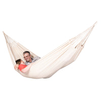 Couple resting in a double size white cotton hammock