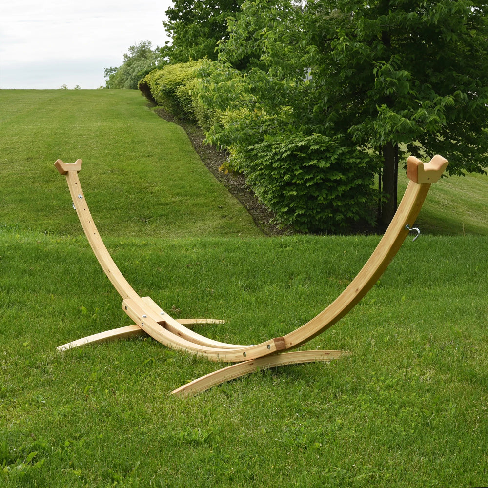 Wooden hammock stand on a grassy field with trees in the background