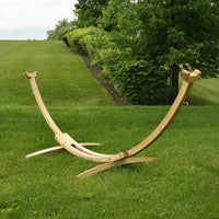 Wooden hammock stand on a grassy field with trees in the background