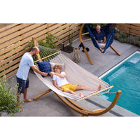 Family all relaxing in hammocks beside a swimming pool