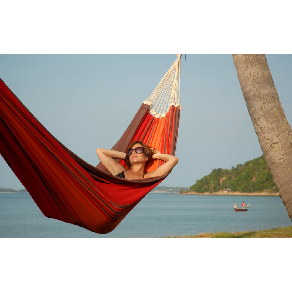 Woman relaxing in hammock on beach
