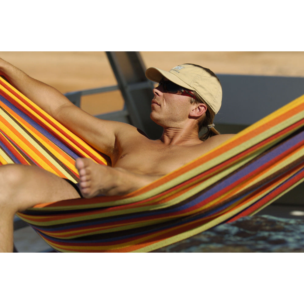 Man relaxing in colourful hammock