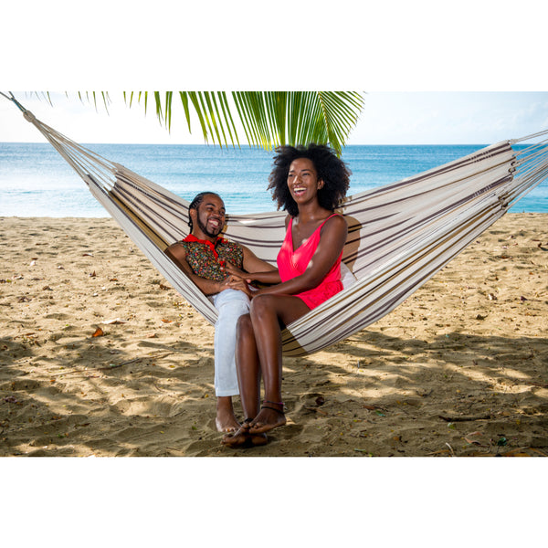 Cotton hammock on beach with couple