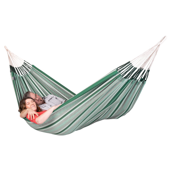 Couple resting in a green and white hammock