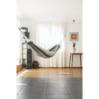 Single cotton hammock hung from walls inside