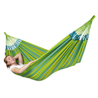Woman lying back in a bright green and yellow hammock