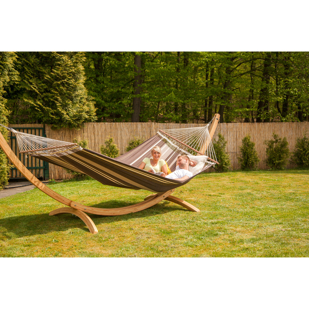 couple relaxing on large hammock on frame in garden