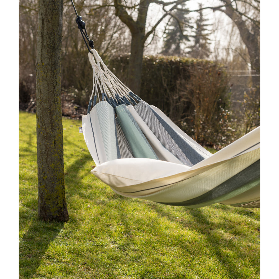 Cotton striped hammock hung between two trees