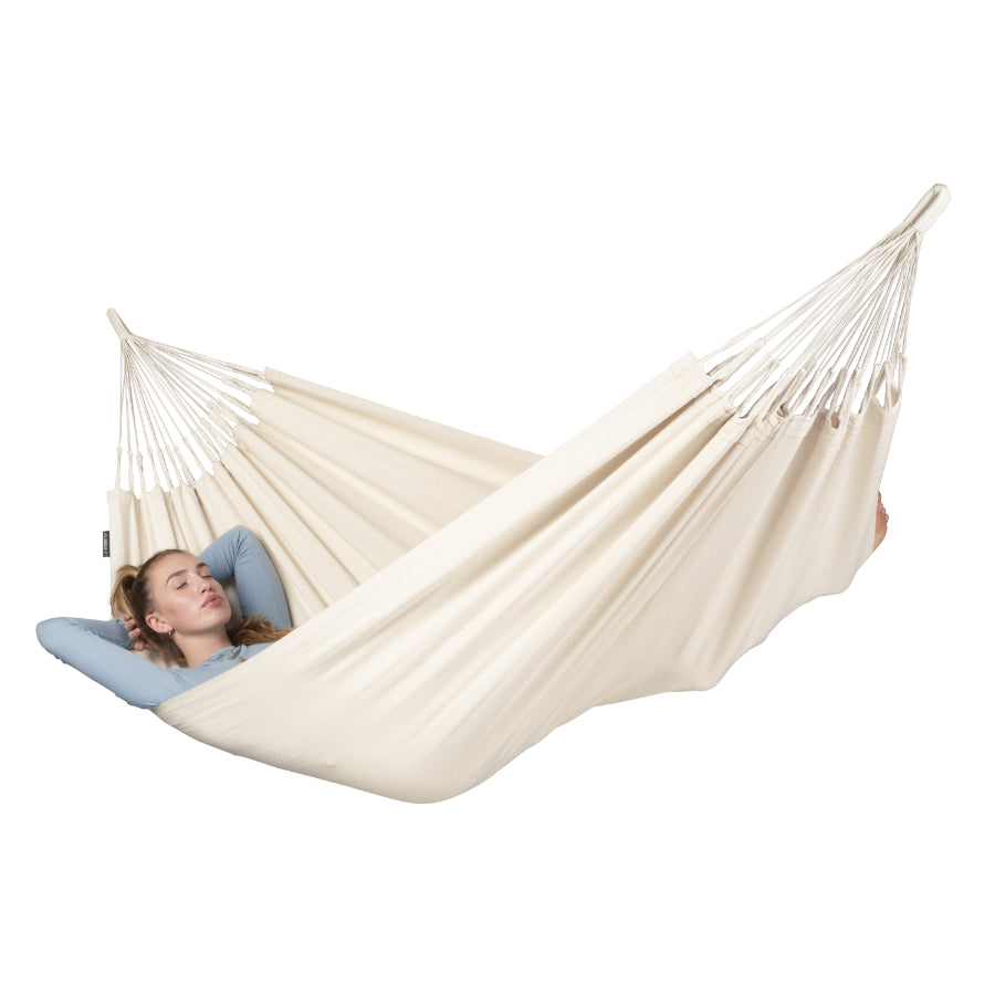 Single white cotton hammock with woman sleeping in