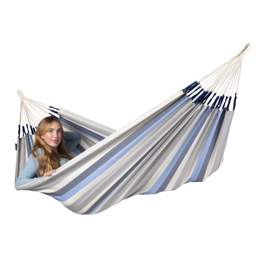 Woman relaxing in white and blue hammock